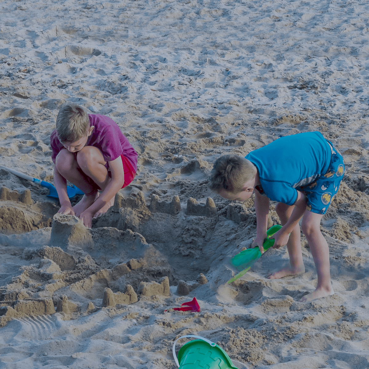 Kids building sandcastles on the private beach